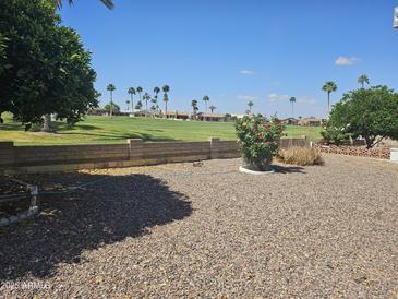 A well-manicured backyard with a golf course in the background and flower bed in the foreground at 2528 N Lema Dr, Mesa, AZ 85215