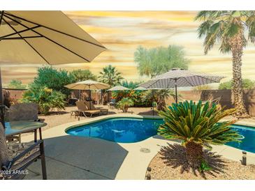 Inviting backyard pool area, perfect for relaxing with lounge chairs and desert landscaping at 43036 W Anne Ln, Maricopa, AZ 85138