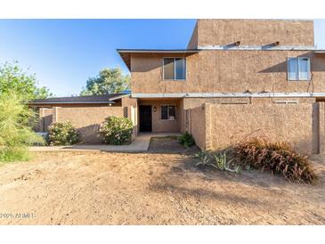 Exterior view of a two-story townhome featuring desert landscaping and a private front patio at 6902 W Devonshire Ave # 1280, Phoenix, AZ 85033