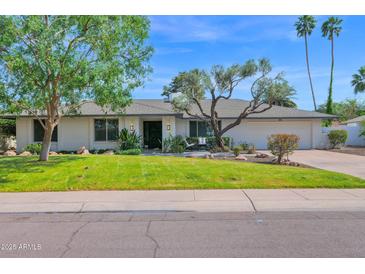 Charming single-story home featuring a well-manicured lawn and mature trees, creating a welcoming curb appeal at 8582 E Via De Dorado --, Scottsdale, AZ 85258