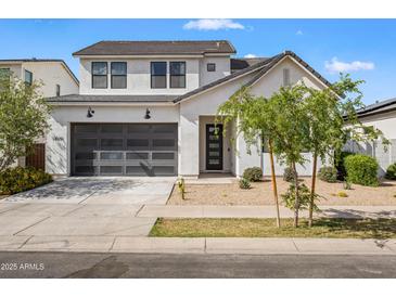 Charming two-story home featuring a modern garage door, low-maintenance landscaping, and a neutral color palette at 10034 E Thunderbolt Ave, Mesa, AZ 85212