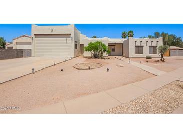 Stylish home with desert landscaping, a two-car garage, and a neutral color palette at 1018 E Knoll St, Mesa, AZ 85203