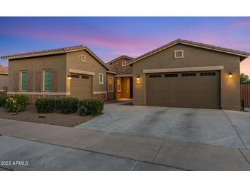 Charming single-Gathering home featuring desert landscaping, multi-car garage, and a welcoming facade under a beautiful twilight sky at 21283 E Camacho Rd, Queen Creek, AZ 85142
