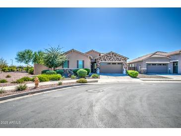 Charming single-story home featuring stone accents, a two-car garage, and meticulously maintained landscaping at 21551 E Waverly Ct, Queen Creek, AZ 85142