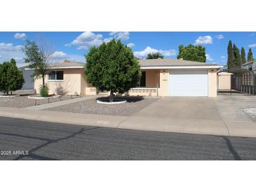 Well-maintained home featuring lovely landscaping, mature tree, and a two-car garage at 235 N 61St Pl, Mesa, AZ 85205