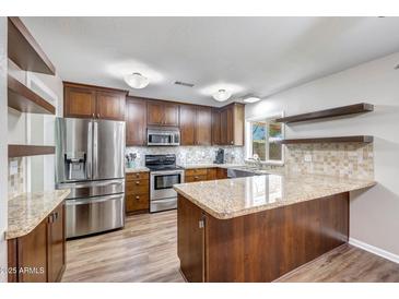 Beautiful kitchen with granite countertops, stainless steel appliances, and wooden cabinets at 4808 W Shaw Butte Dr, Glendale, AZ 85304