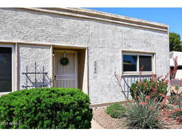 Charming home entrance featuring a textured facade, decorative ironwork, and vibrant landscaping at 5942 N 83Rd St, Scottsdale, AZ 85250