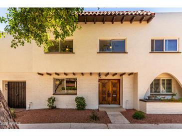 Charming two-story home with unique architectural details and a well-maintained front yard at 7665 E Montecito Ave, Scottsdale, AZ 85251