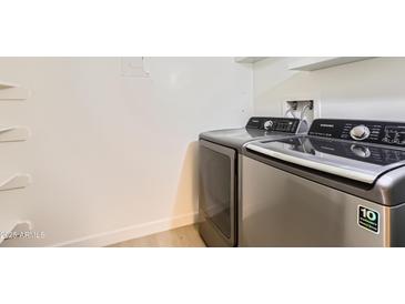 Modern washer and dryer units in a dedicated laundry area with storage shelves at 7970 E Camelback Rd # 110, Scottsdale, AZ 85251