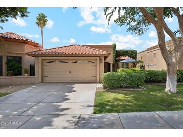 Charming single-story home features a terracotta roof, mature landscaping, and a two-car garage at 9460 N 105Th Pl, Scottsdale, AZ 85258