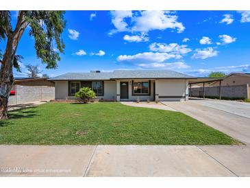 Charming single-story home featuring a well-manicured lawn and neutral tones at 1444 W Wickieup Ln, Phoenix, AZ 85027