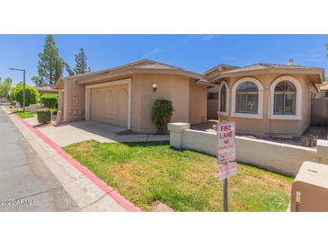Charming single-story home with a well-manicured lawn and two-car garage at 18002 N 12Th St # 45, Phoenix, AZ 85022