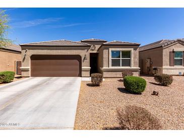 Beautiful single-story home featuring a two car garage and a well-maintained xeriscaped front yard at 36454 W Picasso St, Maricopa, AZ 85138