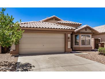 A charming single-story home with a two-car garage, desert landscaping and tile roof at 16120 N 86Th Ln, Peoria, AZ 85382