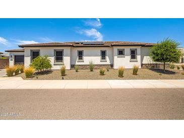 Attractive single-story home featuring desert landscaping, light stucco, and dark trim set against a bright, sunny sky at 17376 W Wildwood St, Surprise, AZ 85388