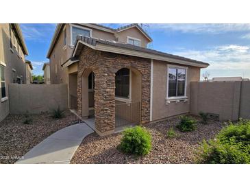 Charming two-story home featuring a beautiful stone facade, landscaped yard, and inviting walkway at 17802 N 114Th Ln, Surprise, AZ 85378