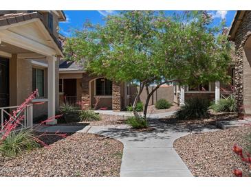 Landscaped front yard with a charming home, stone facade, and inviting walkway at 17802 N 114Th Ln, Surprise, AZ 85378