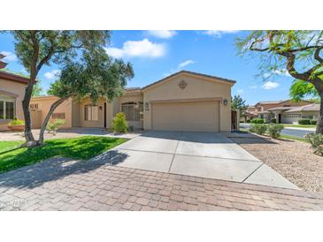 Charming single-story home with a well-manicured lawn and a two-car garage on a sunny day at 2031 W Periwinkle Way, Chandler, AZ 85248
