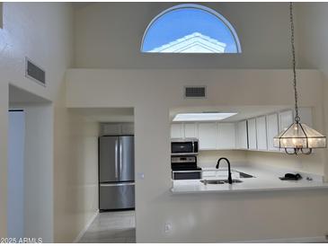 Bright kitchen features stainless steel appliances and modern lighting fixtures at 2100 W Lemon Tree Pl # 29, Chandler, AZ 85224
