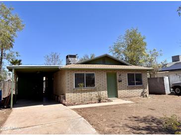 Charming single-story home featuring a covered carport, neutral brick, and a well-kept front yard at 2134 E Harvard St, Phoenix, AZ 85006