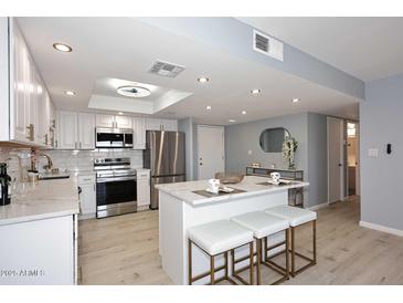 Charming kitchen features a center island, stainless steel appliances, and stylish lighting at 7920 E Camelback Rd # 612, Scottsdale, AZ 85251