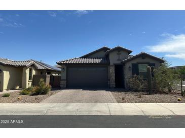 Charming single-story home featuring desert landscaping, a brick driveway and tile roof at 15301 W Moreland St, Goodyear, AZ 85338