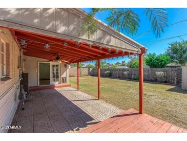 Covered patio has concrete floor, wood roof, and string lights to a grassy backyard at 2213 E Campbell Ave, Phoenix, AZ 85016