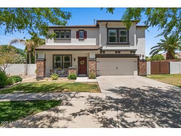 Charming two-story home featuring a well-manicured lawn, covered porch, and attached two-car garage at 3784 E Washington Ct, Gilbert, AZ 85234