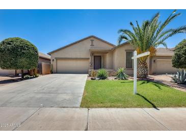 Charming single-story home featuring desert landscaping, green lawn, and a spacious two-car garage at 38125 W Santa Clara Ave, Maricopa, AZ 85138
