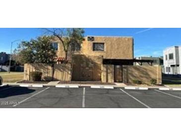 Beige condo with a small tree, short fence, and carport with parking in front of the unit at 5416 W Hearn Rd, Glendale, AZ 85306