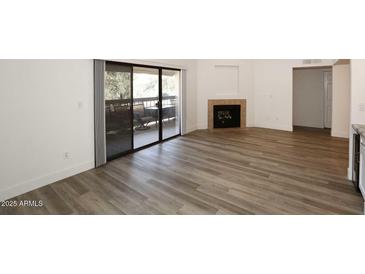 Bright living room features a fireplace and sliding glass door to the patio at 5998 N 78Th St # 222, Scottsdale, AZ 85250