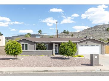 Charming single-story home with xeriscape landscaping and mature trees at 1445 W Wood Dr, Phoenix, AZ 85029