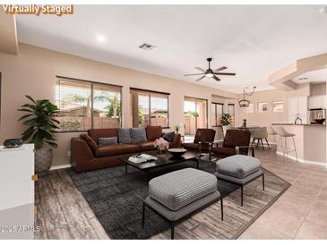 Spacious living room with modern furnishings, ceiling fan, and lots of natural light at 16837 W Northampton Rd, Surprise, AZ 85374