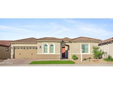 Charming home features desert landscaping, a two-car garage, and a tiled roof at 19045 N 269Th Dr, Buckeye, AZ 85396
