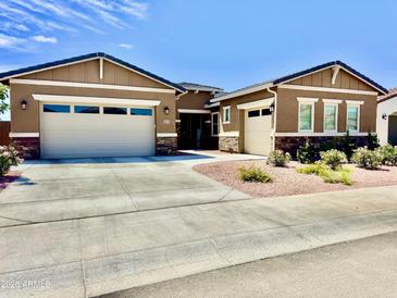 Charming single-story home with a three-car garage and well-manicured front yard at 20171 W Cheery Lynn Rd, Buckeye, AZ 85396