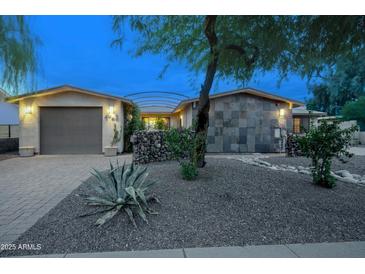 Charming single-story home featuring desert landscaping, stone accents, and a two-car garage at 4008 N 85Th St, Scottsdale, AZ 85251