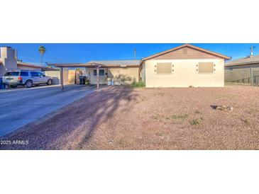View of the house featuring a covered driveway and desert landscaping in the front yard at 4727 N 50Th Dr, Phoenix, AZ 85031