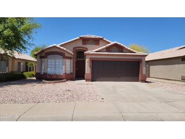 Charming single-story home with a well-maintained front yard and two car garage at 15642 N Naegel Dr, Surprise, AZ 85374