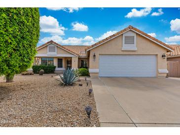 Charming single-story home with a well-maintained desert landscaped front yard and a two-car garage at 16230 E Glenpoint Dr, Fountain Hills, AZ 85268