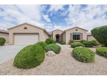 Charming single story home featuring a two car garage, manicured bushes, and desert landscaping at 17192 W Hermosa Dr, Surprise, AZ 85387