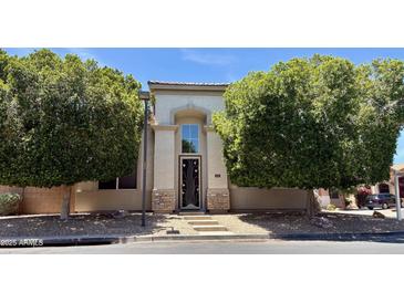 Charming two-story home featuring a stucco facade, decorative front door, and mature shade trees at 2308 S Bernard --, Mesa, AZ 85209