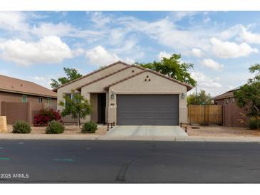 Charming single-story home with a well-maintained front yard and a two-car garage at 25028 W Wayland Dr, Buckeye, AZ 85326