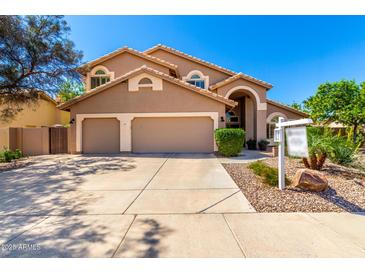 Charming tan home with a three-car garage, arched entry, and professionally landscaped front yard at 3581 W Ironwood Dr, Chandler, AZ 85226