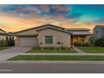 Charming single-story home with manicured lawn and desert landscaping at sunset at 3929 E Bloomfield Pkwy, Gilbert, AZ 85296