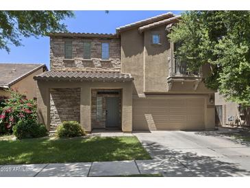 Inviting two-story home featuring a stone facade, a two-car garage, and a charming balcony, nestled in a tranquil neighborhood at 4366 E Lexington Ave, Gilbert, AZ 85234