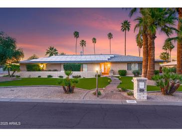 Charming home featuring desert landscaping, solar panels, and beautiful sunset lighting at 5402 E Larkspur Dr, Scottsdale, AZ 85254