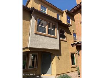 Exterior shot showcasing three-story building with stone accents and desert landscaping at 7722 W Pipestone Pl, Phoenix, AZ 85035