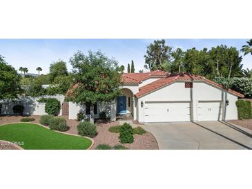 Beautiful home featuring a red tile roof, attached two car garage and a blue front door at 8943 N 80Th Pl, Scottsdale, AZ 85258