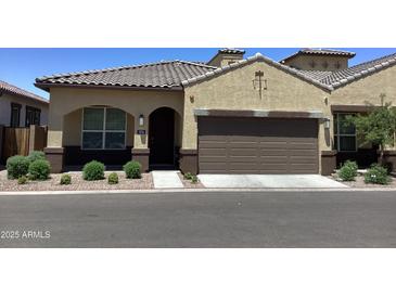 Inviting home exterior showcasing a tile roof, a two car garage, and well-manicured landscaping at 1255 N Arizona Ave # 1216, Chandler, AZ 85225