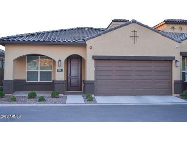 Inviting single-story home showcasing a well-maintained front yard, stylish brown garage door and desert landscaping at 1255 N Arizona Ave # 1216, Chandler, AZ 85225